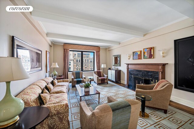 living area with visible vents, a high end fireplace, wood finished floors, beamed ceiling, and baseboards