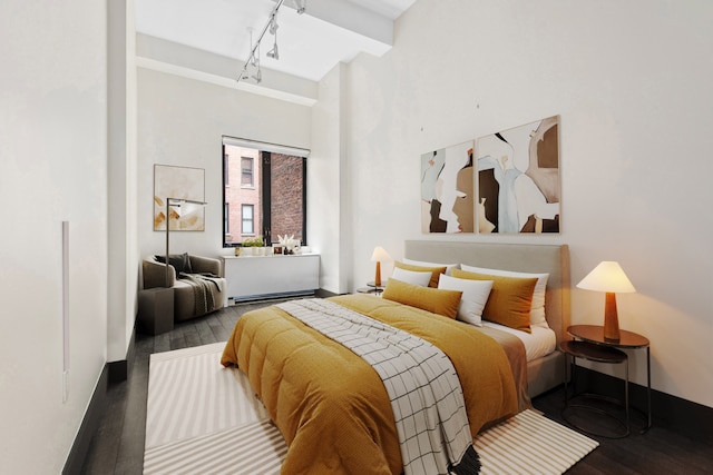 bedroom featuring rail lighting and wood finished floors