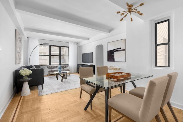 dining space with arched walkways, beam ceiling, and baseboards