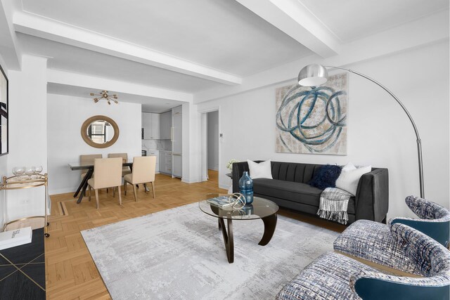 living room featuring beamed ceiling and baseboards