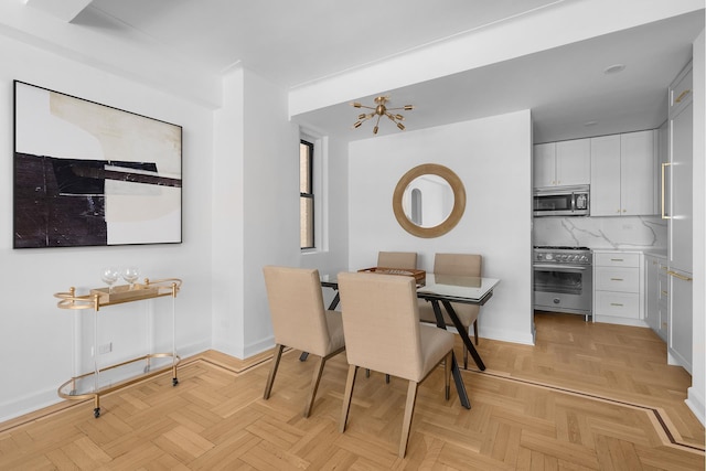 225 E 79th St Unit 7Cd, New York City, NY 10075 - dining room featuring baseboards and a chandelier