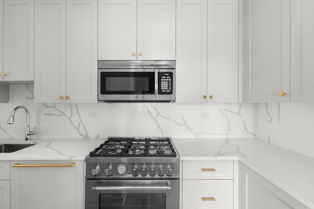 225 E 79th St Unit 7Cd, New York City, NY 10075 - kitchen with appliances with stainless steel finishes, a sink, backsplash, and white cabinetry