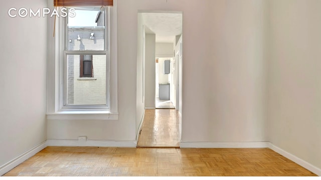 unfurnished room with baseboards