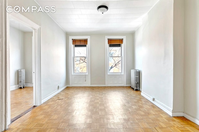 unfurnished room featuring baseboards and radiator heating unit