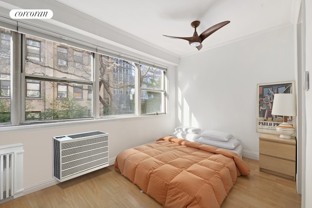 bedroom featuring heating unit, radiator heating unit, ornamental molding, wood finished floors, and baseboards