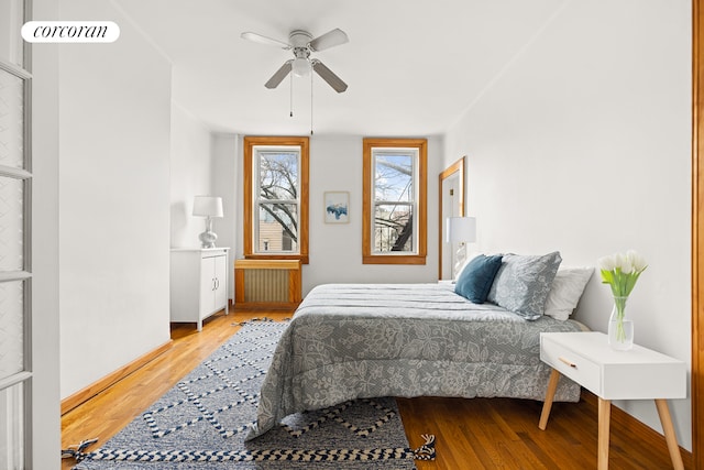 bedroom featuring a ceiling fan, visible vents, and wood finished floors