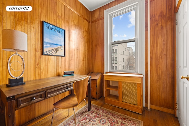 office space with wood walls and wood finished floors