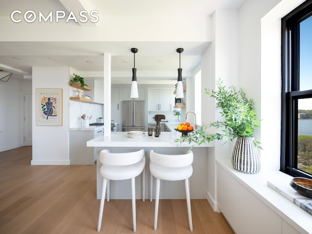 dining space with an inviting chandelier, light wood-style floors, baseboards, and beamed ceiling