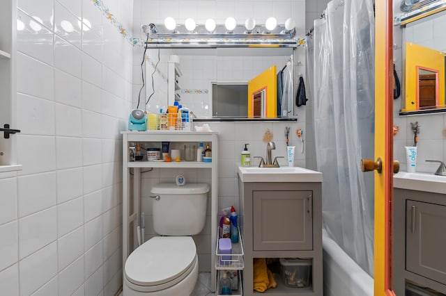 full bathroom with shower / bath combination with curtain, tile walls, vanity, and toilet