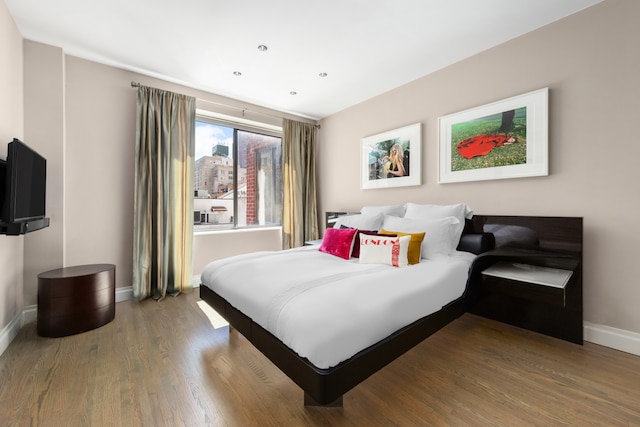 bedroom featuring baseboards and wood finished floors