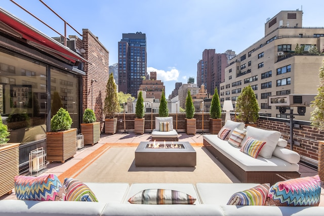 view of patio with an outdoor living space with a fire pit and a city view