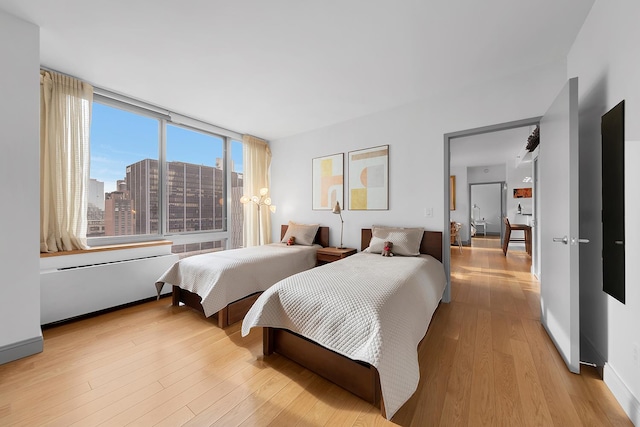 bedroom with light wood-type flooring and baseboards