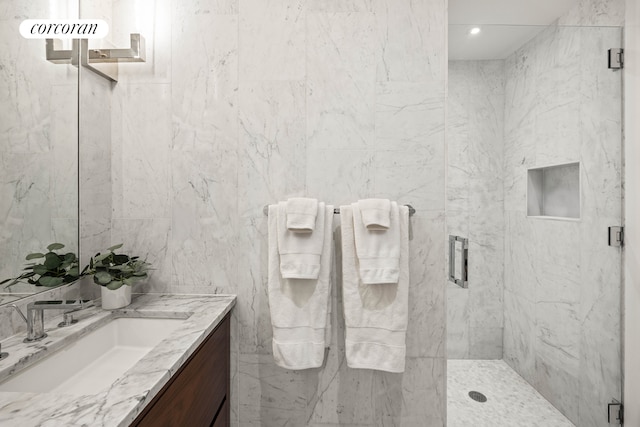 bathroom with a stall shower, recessed lighting, tile walls, and vanity