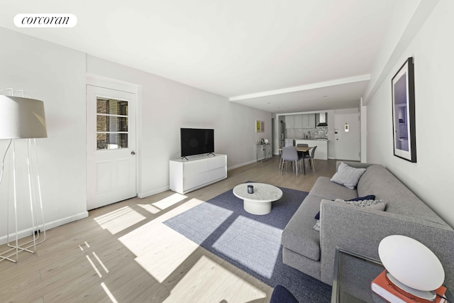 living room featuring visible vents, baseboards, and wood finished floors