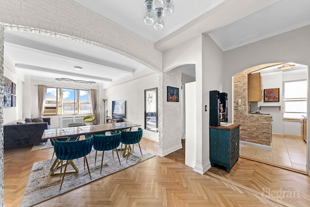 dining area with a wealth of natural light, beamed ceiling, arched walkways, and baseboards