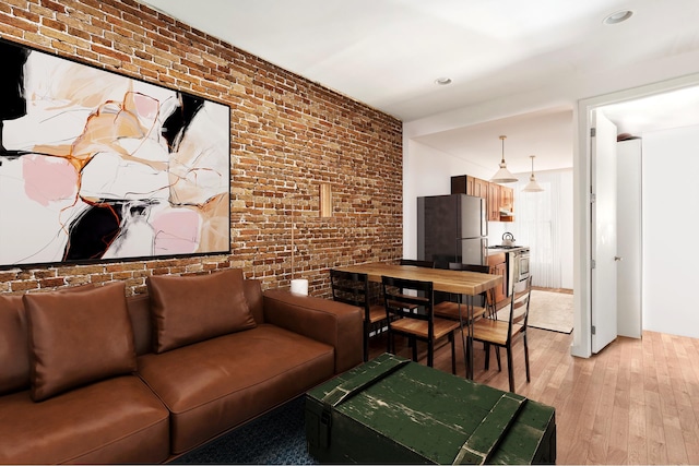 living room featuring brick wall and light wood finished floors