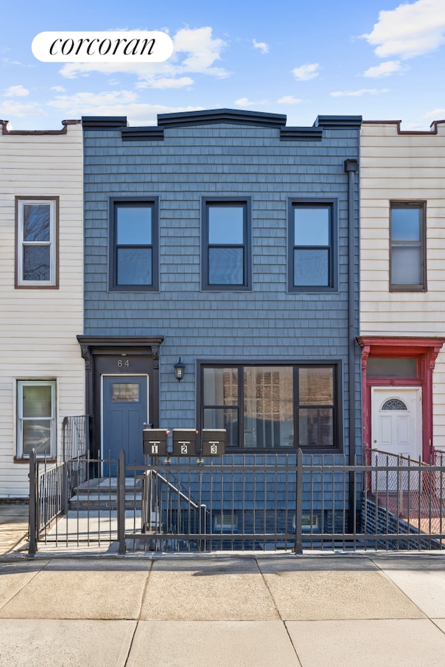 townhome / multi-family property featuring a fenced front yard