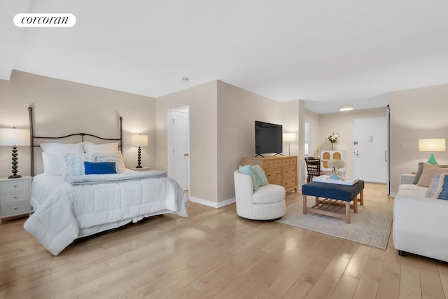 bedroom featuring baseboards, visible vents, and wood finished floors