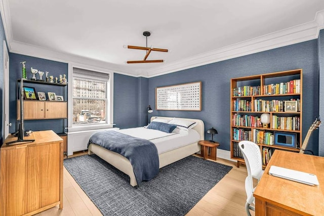 bedroom featuring ornamental molding and light wood-style floors