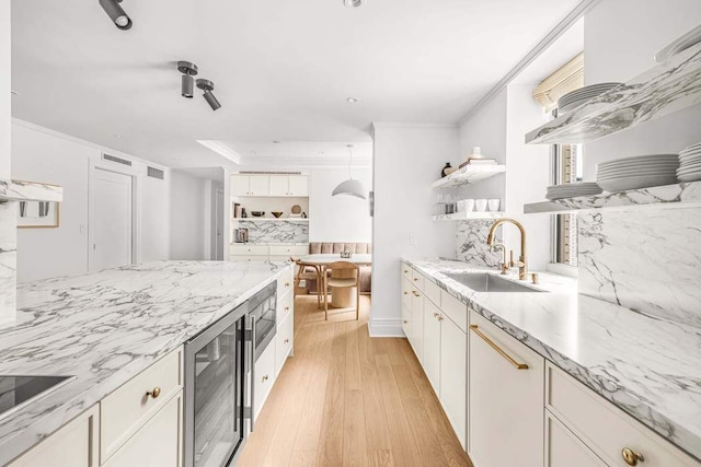 kitchen featuring white cabinetry, a sink, and open shelves