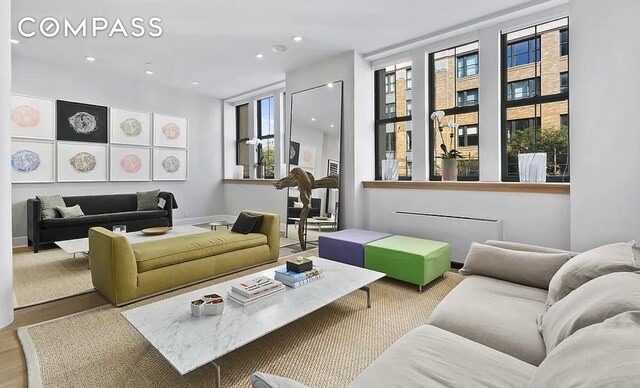 living area featuring baseboards and recessed lighting