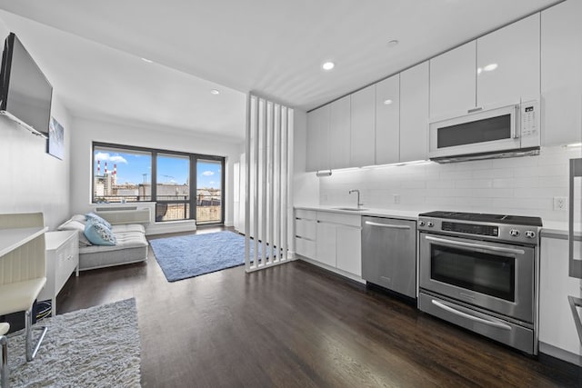 kitchen featuring stainless steel appliances, dark wood-type flooring, white cabinets, and light countertops