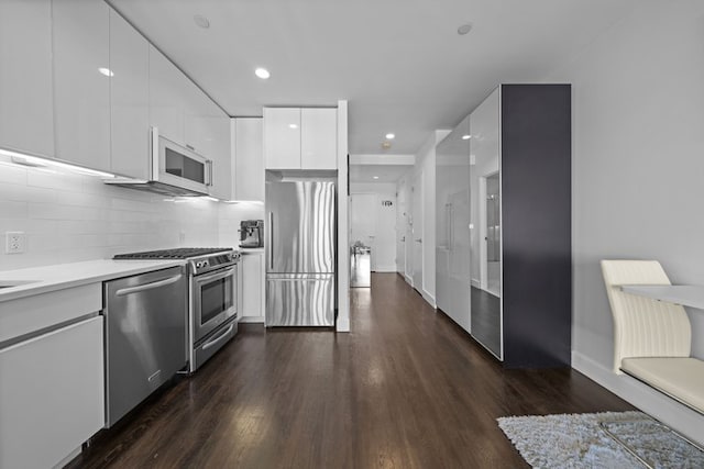 kitchen with modern cabinets, dark wood-style flooring, stainless steel appliances, light countertops, and white cabinetry