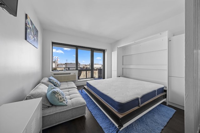 bedroom with cooling unit and wood finished floors