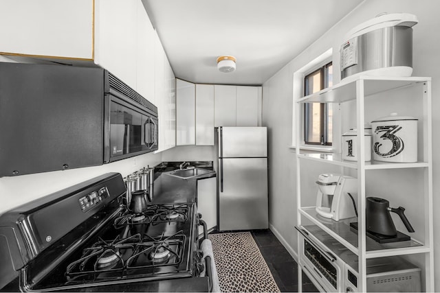 kitchen featuring light countertops, white cabinets, black appliances, and modern cabinets