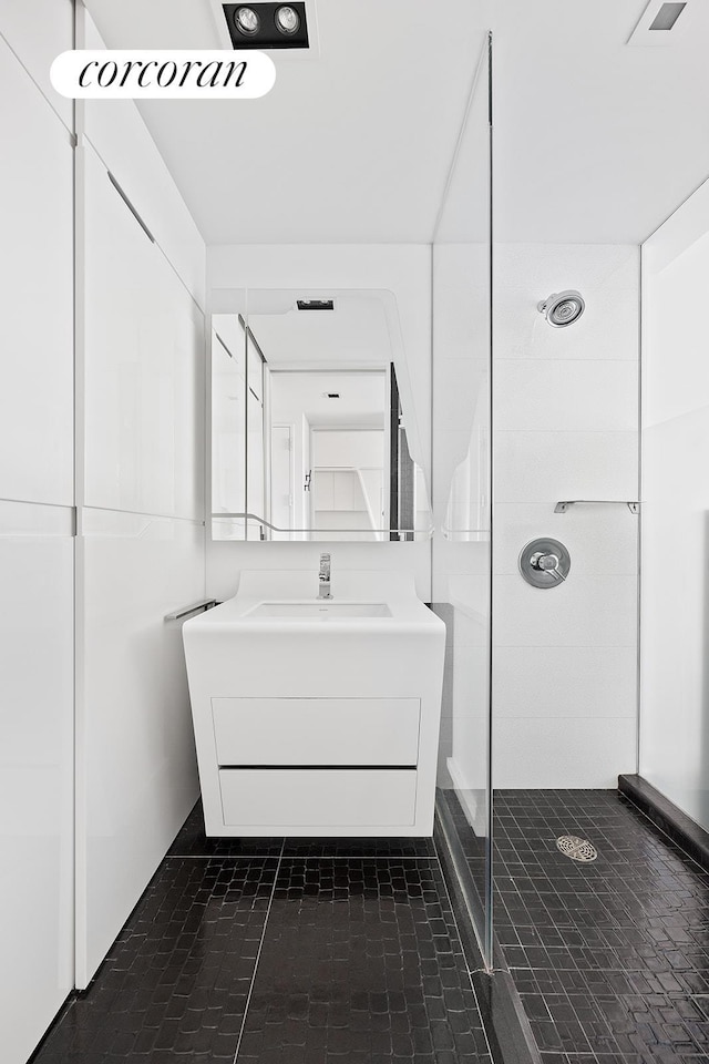 bathroom featuring a tile shower and vanity