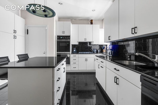 kitchen with dark countertops, a kitchen breakfast bar, white cabinets, and dark tile patterned flooring