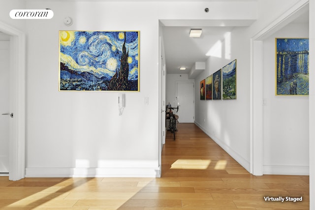 corridor featuring baseboards and wood finished floors