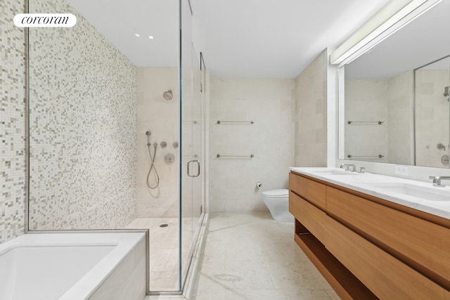 full bath featuring a stall shower, a garden tub, a sink, and toilet