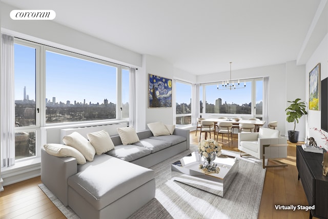 living area with a view of city, visible vents, plenty of natural light, and hardwood / wood-style flooring