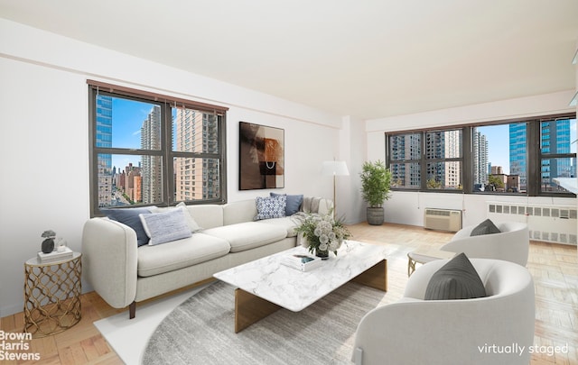 living room featuring radiator, a city view, and a wall unit AC