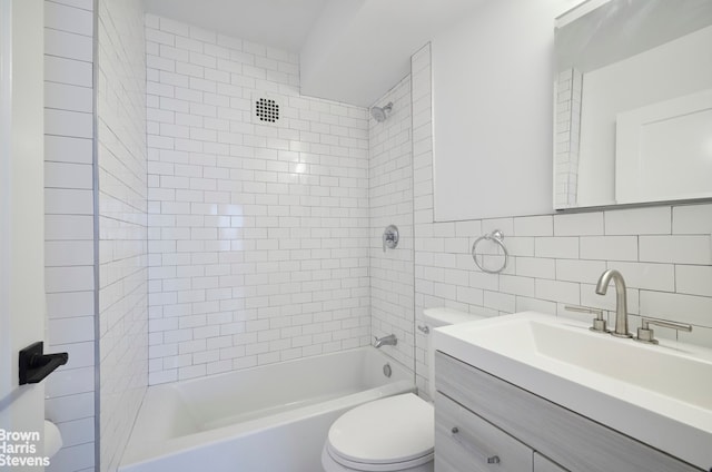 full bath with tile walls, decorative backsplash, toilet, vanity, and  shower combination