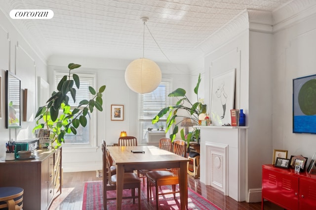 dining space featuring dark wood-style floors, baseboards, visible vents, and crown molding