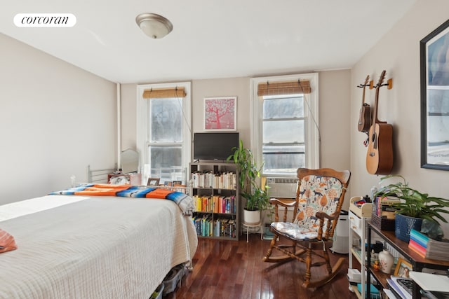 bedroom with cooling unit, dark wood finished floors, and visible vents