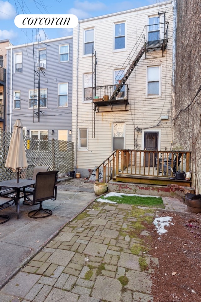 rear view of house featuring a patio and fence