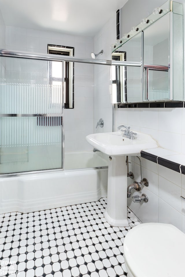 3840 Greystone Ave Unit 2O, New York City, NY 10463 - bathroom featuring enclosed tub / shower combo, toilet, tile walls, and tasteful backsplash