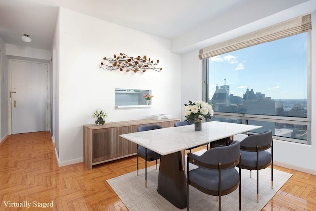 dining area featuring radiator, a view of city, and baseboards