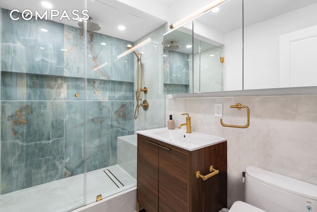 full bath with a marble finish shower, tasteful backsplash, vanity, and toilet