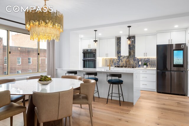 dining space featuring recessed lighting, an inviting chandelier, and light wood finished floors