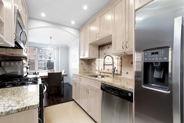 310 E 70th St Unit 10E, New York City, NY 10021 - kitchen with appliances with stainless steel finishes, a sink, ornamental molding, tasteful backsplash, and a chandelier