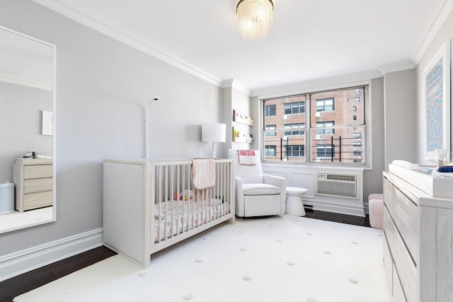 310 E 70th St Unit 10E, New York City, NY 10021 - bedroom with crown molding, a wall mounted air conditioner, wood finished floors, and baseboards