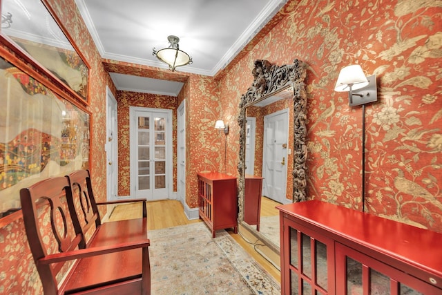 interior space with ornamental molding, wood finished floors, and wallpapered walls