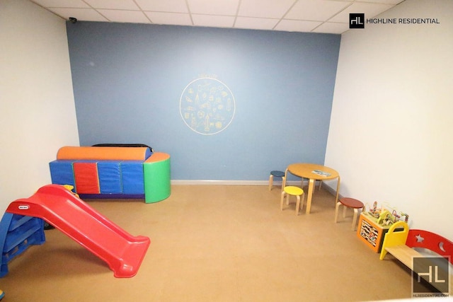 game room featuring a drop ceiling and baseboards