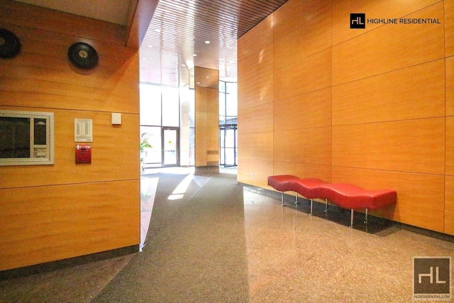 250 E 40th St Unit 4A, New York City, NY 10016 - common area featuring floor to ceiling windows, wood walls, and a high ceiling