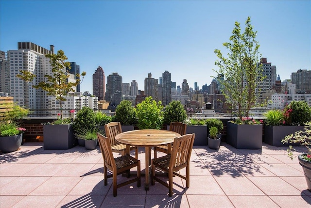 view of patio / terrace featuring outdoor dining space and a city view