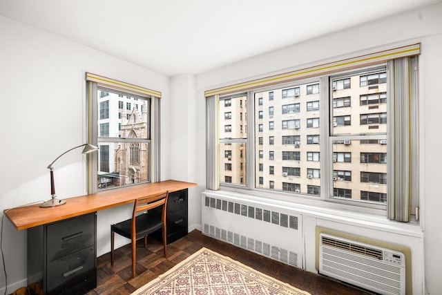 office space with radiator, a wall mounted air conditioner, and baseboards